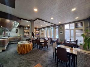 a restaurant with tables and chairs and a kitchen at Hostel Imran Zenica in Zenica