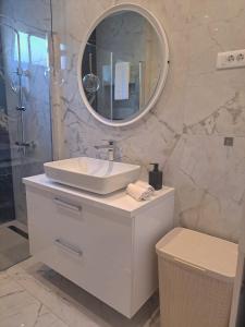 een witte badkamer met een wastafel en een spiegel bij Apartment Maris in Podstrana