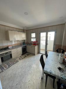 a kitchen with a table and a table and chairs at bel appart mosta in Mostaganem