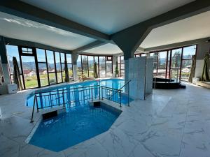 a large swimming pool in a building with windows at Vlasic Odmor - Villa Wellnes & spa in Vlasic