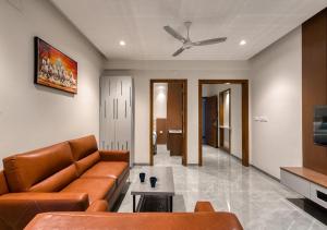 a living room with a couch and a ceiling fan at J Square Inn in Coimbatore