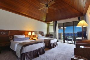 Habitación de hotel con 2 camas y balcón en Aqua Resort Club Saipan, en Saipán