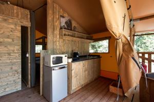 a kitchen in a tiny house with a refrigerator at Lodge du Berlandou in Escragnolles
