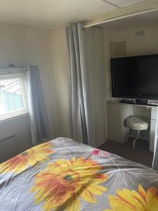 ein Schlafzimmer mit einem Bett mit Blumendesign in der Unterkunft Red 2 Caravan Ingoldmells 6 berth 3 bedrooms in Ingoldmells