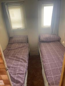 2 Betten in einem kleinen Zimmer mit 2 Fenstern in der Unterkunft Red 2 Caravan Ingoldmells 6 berth 3 bedrooms in Ingoldmells