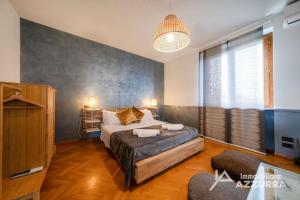 a bedroom with a bed and a large window at Villa i Roccoli - Immobiliare Azzurra in Bardolino