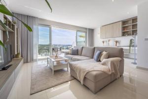 sala de estar con sofá y ventana grande en Modern 3 Bedrooms Penthouse With A Breathtaking Valletta View, en Sliema