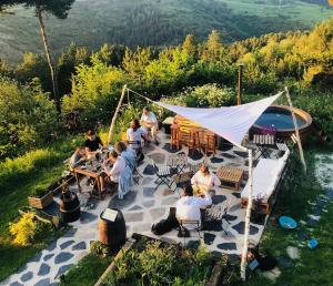 Minds & Mountains Eco Lodge في لا مولينا: مجموعة من الناس يجلسون على الطاولات في الفناء