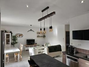 cocina y sala de estar con mesa y comedor en Appartement intra-muros, en Aviñón