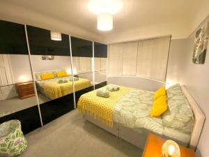 1 Schlafzimmer mit 2 Betten und einem Spiegel in der Unterkunft 4 Bedroom House near City Centre with Parking in Gloucester