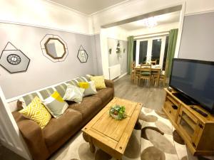 sala de estar con sofá y TV de pantalla plana en 4 Bedroom House near City Centre with Parking en Gloucester