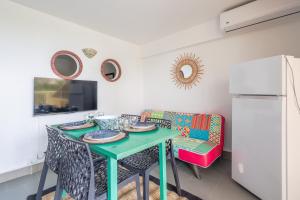 a dining room with a green table and chairs at L'Isula - Appt pour 5 climatisé avec piscine in LʼÎle-Rousse