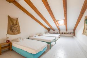 een groep van vier bedden in een kamer met houten plafonds bij Le Rocher - Appt pour 6 climatisé avec piscine in LʼÎle-Rousse