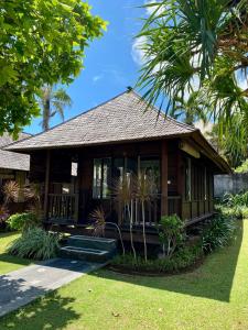 ein Resort mit einem Gebäude mit einer Veranda in der Unterkunft Balangan Surf Resort in Jimbaran