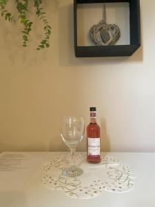 Einzelzimmer Nr. 4 in Kleve في كليفي: زجاجة من النبيذ وكأس من النبيذ على الطاولة