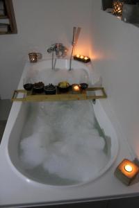 a bath tub with candles and cupcakes in it at Versveld Cottage in Yzerfontein +22 photos