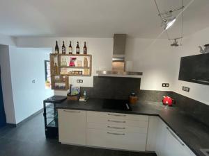 a kitchen with white cabinets and a black counter top at Chez mémé d'Hecq in Hecq
