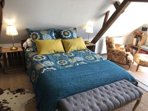a bedroom with a bed with a blue blanket at Chez mémé d'Hecq in Hecq