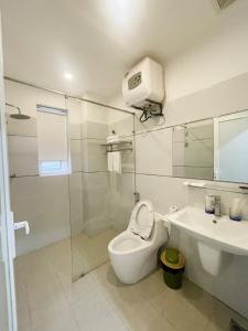 een witte badkamer met een toilet en een wastafel bij GEM Apartment & Hotel in An Khê