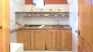 een keuken met een wastafel en een fornuis bij Sea View, Nature & Barbecue - Authentic "Dammusi" in Pantelleria