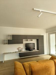 a living room with a couch and a flat screen tv at Regina design apartment Lugano in Lugano