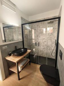 a bathroom with a sink and a glass shower at Regina design apartment Lugano in Lugano