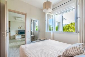 una camera bianca con un letto e una grande finestra di The Holiday House 1 a Kavrokhórion
