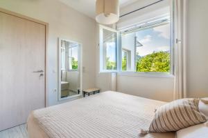 a bedroom with a bed and a large window at The Holiday House 1 in Kavrokhórion