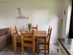 a dining room table and chairs with a vase on it at Cosy cottage between Penzance and St Ives in Gulval