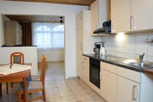 eine Küche mit einem Tisch und einem Esszimmer in der Unterkunft Appartmenthaus Rosenhof in Podersdorf am See