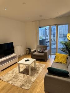 a living room with a tv and a couch and a table at Lovely 1-Bed Apartment in London in London