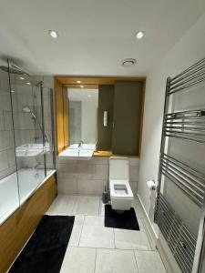 a bathroom with a toilet and a sink and a tub at Lovely 1-Bed Apartment in London in London