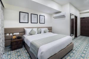 1 dormitorio con 1 cama grande en una habitación en Aashreya Suites Tiruvannamalai en Tiruvannāmalai