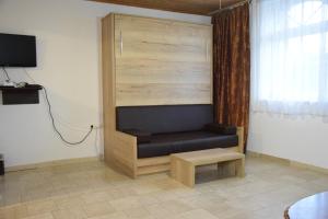 un sofá en una habitación con mesa y TV en Appartmenthaus Rosenhof en Podersdorf am See