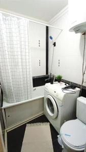 een badkamer met een wasmachine en een toilet bij 2 комнатная квартира в центре города in Karagandy