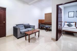 a living room with a couch and a table at Aashreya Suites Tiruvannamalai in Tiruvannāmalai