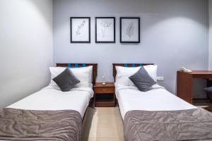 two beds sitting next to each other in a room at Aashreya Suites Tiruvannamalai in Tiruvannāmalai
