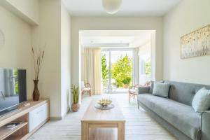 a living room with a couch and a tv at The Holiday House 1 in Kavrokhórion