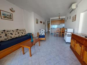 a living room with a couch and a kitchen at Marina 1 in Es Pujols