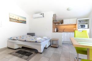 - une petite cuisine avec un lit dans une chambre dans l'établissement Apartmaji Ema, à Koper