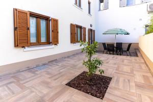 a courtyard of a house with a table and an umbrella at Apartmaji Ema in Koper
