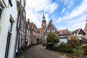an alley of brick houses with a church in the background at Cosy Hotel in Historical Center of Blokzijl in Blokzijl