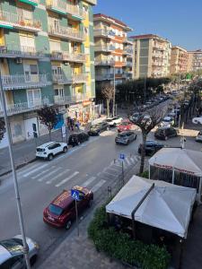 ruchliwa ulica miejska z samochodami zaparkowanymi na drodze w obiekcie Greta's Apartment w mieście San Giorgio a Cremano