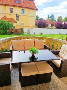 a patio with a table and chairs and a house at PAŁACYK BUDGET in Legnica