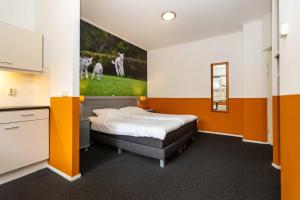 a bedroom with a bed with a painting on the wall at Cosy Hotel in Historical Center of Blokzijl in Blokzijl