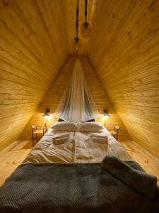 a bedroom with a bed in a wooden room at Sunny side cottage in Kazbegi