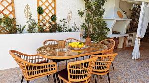 a table with chairs and a bowl of fruit on it at Vithos in Agnontas
