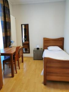 Schlafzimmer mit einem Bett, einem Schreibtisch und einem Tisch in der Unterkunft Beaumane Rooms in Caux sur Montreux