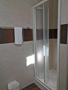 a shower with a glass door in a bathroom at Beaumane Rooms in Caux sur Montreux