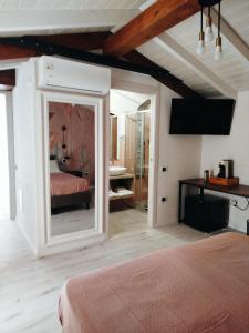 - une chambre avec un lit et un miroir dans l'établissement Antico Centro Quartu B&B, à Quartu SantʼElena